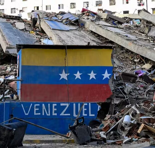 115455424 a venezuelan flag is seen painted on a damaged wall amid the rubble of a collapsed buildin