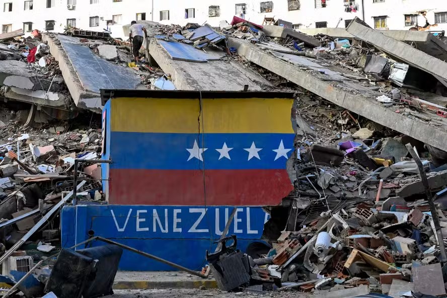115455424 a venezuelan flag is seen painted on a damaged wall amid the rubble of a collapsed buildin