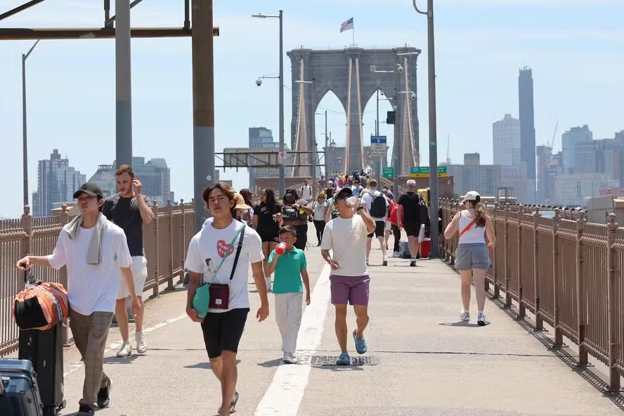 107384789 new york new york june 20 people walk along the brooklyn bridge amid a heat wave on june