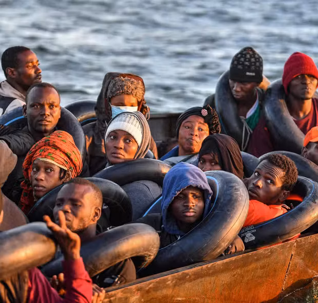 100727418 topshot migrants from sub saharan africa sit in a makeshift boat that was being used to