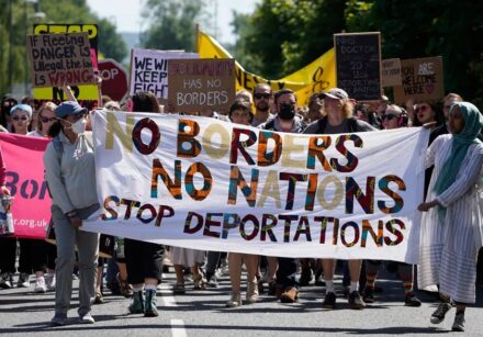 99534132 protesters hold up placards as they march towards the brook house immigration removal c