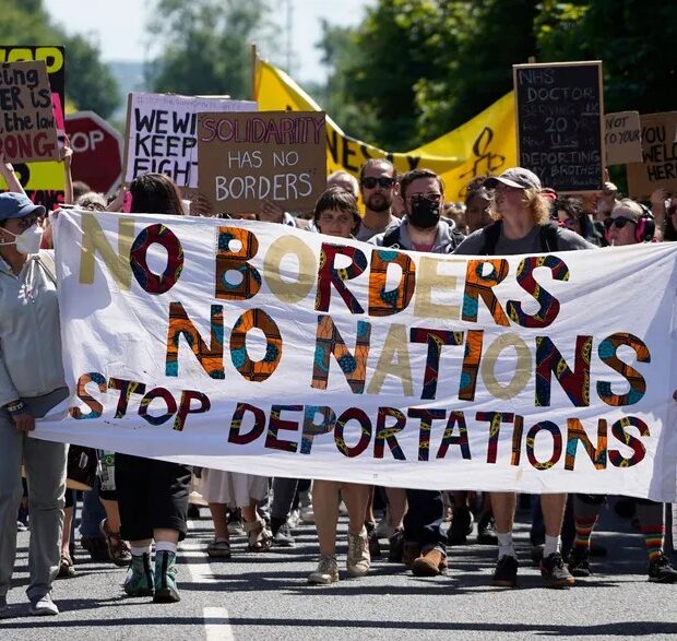 99534132 protesters hold up placards as they march towards the brook house immigration removal c