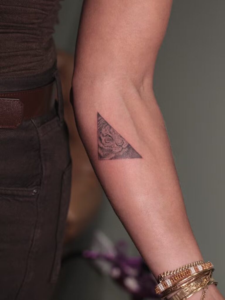 Além da onça, Grazi também tatuou uma tigresa dentro de um triângulo no antebraço esquerdo