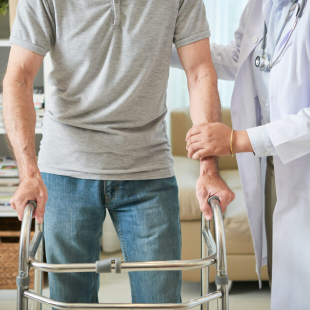 crop doctor helping senior man with walker
