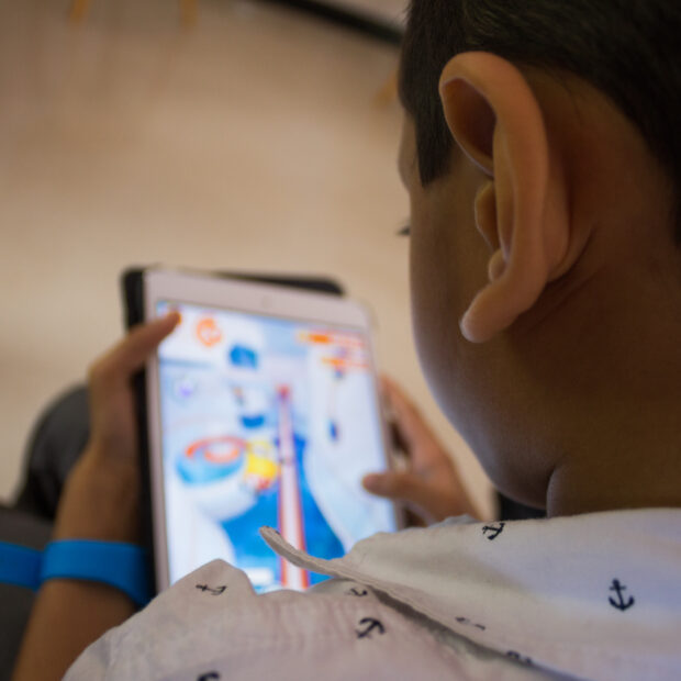 a little boy playing a game on his tablet