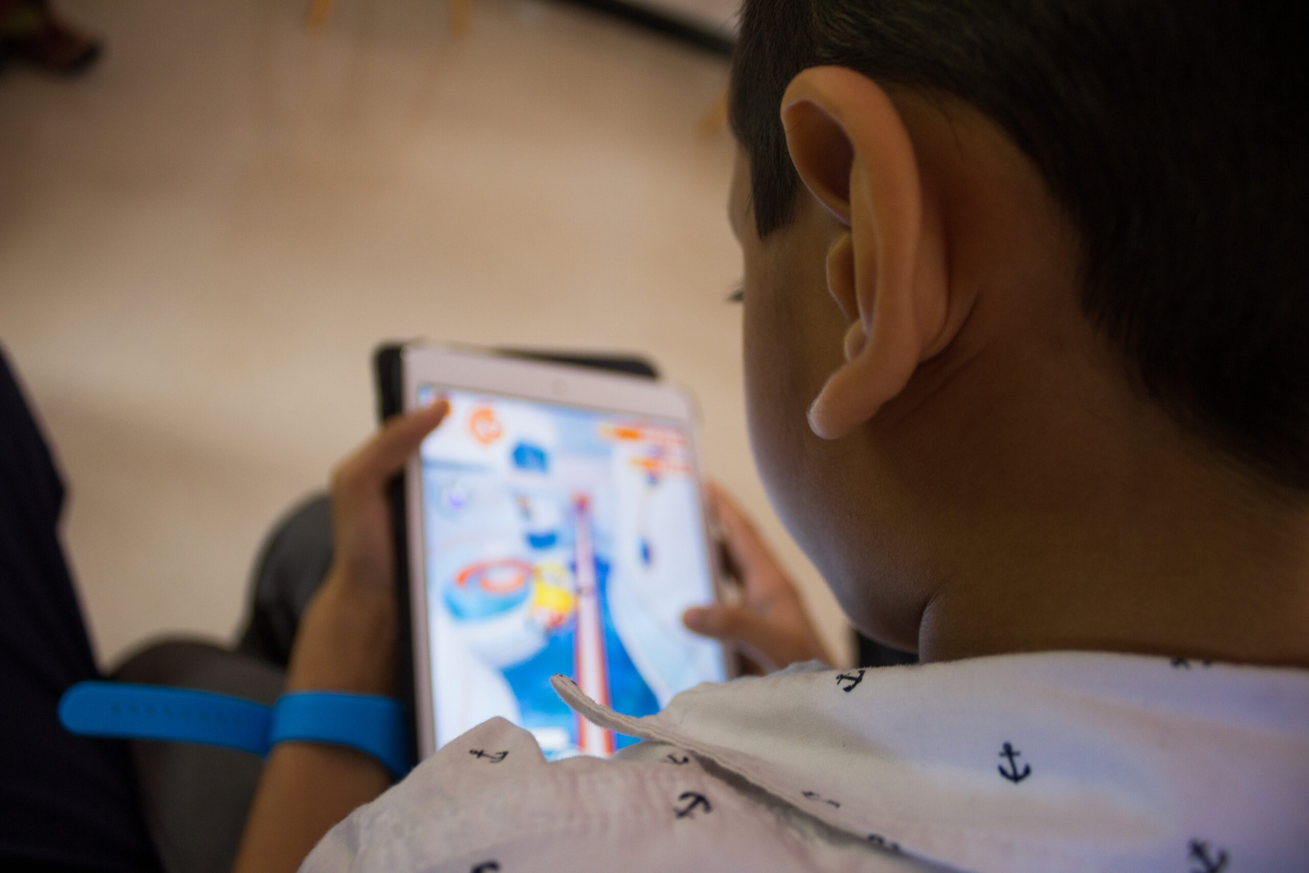 a little boy playing a game on his tablet