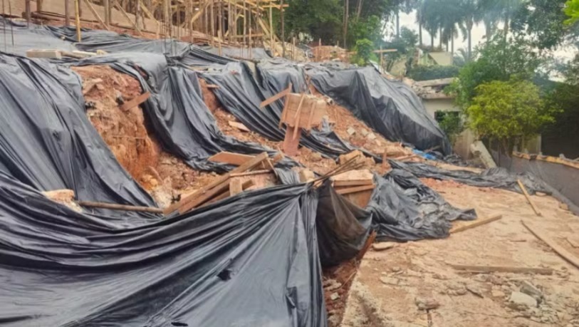 Lama e escombros atingiram a residência vizinha após o desabamento do muro
