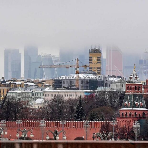 90896839 a woman walks in front of the kremlin and skyscrapers of the moscow international business