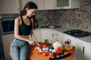 sports girl in a kitchen with vegetables