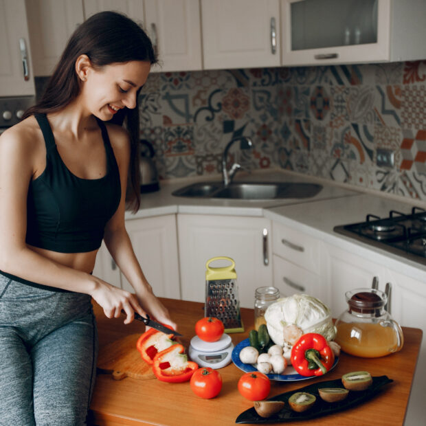 sports girl in a kitchen with vegetables