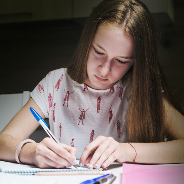 girl doing homework table