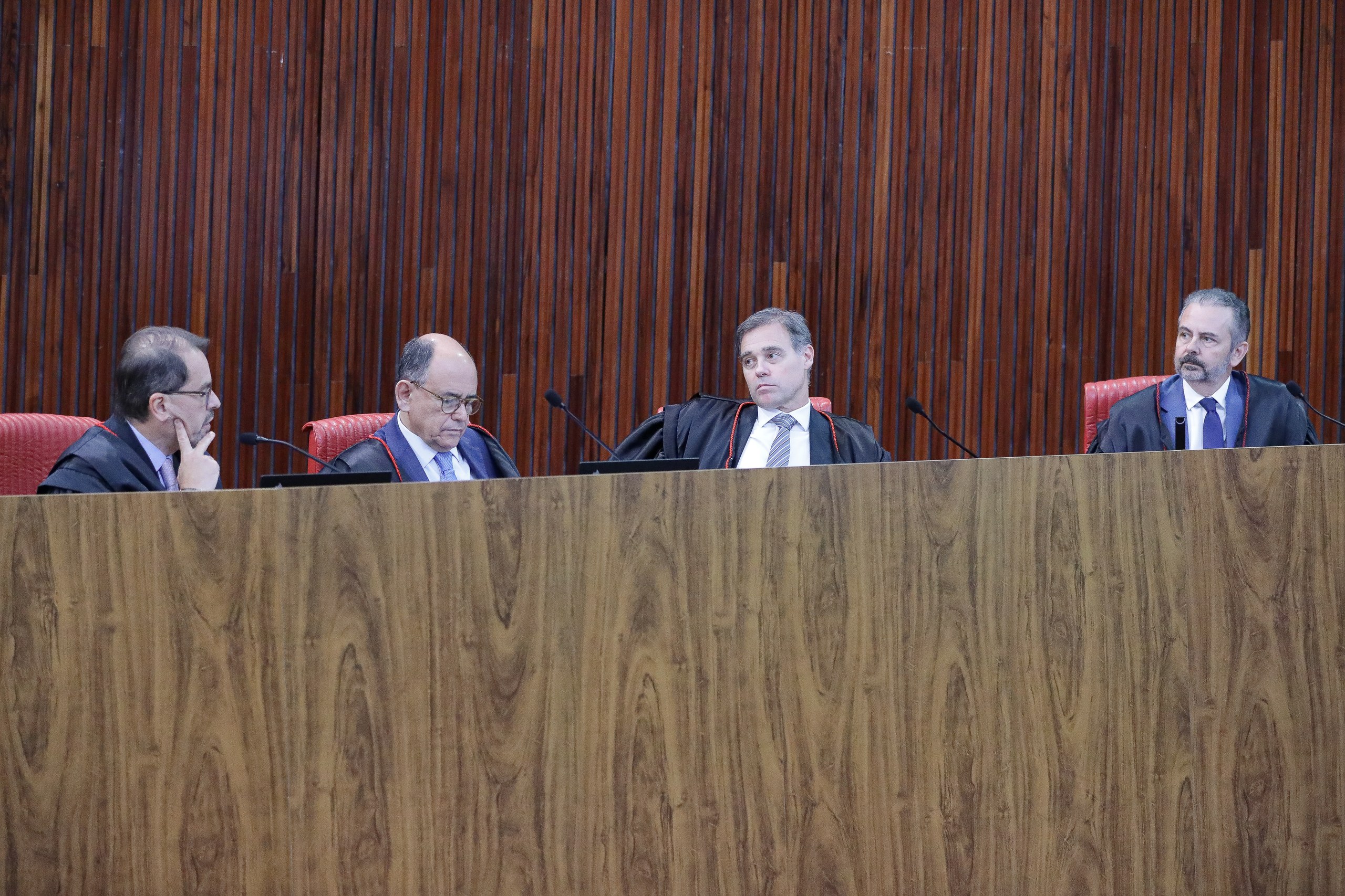 Quatro juízes trajando togas negras sentados à mesa durante uma sessão em um tribunal. Na foto: André Mendonça.