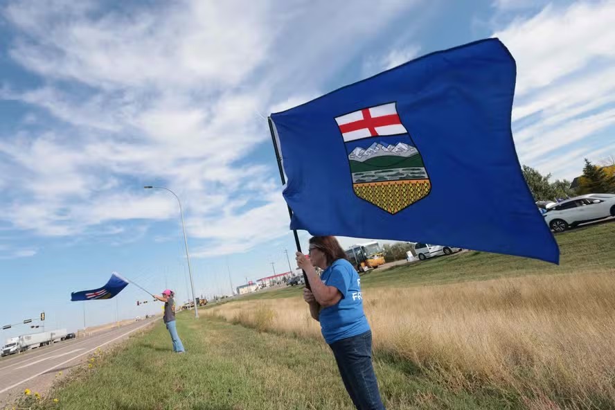 116438238 separatists waves the alberta flag by the roadside during an event advocating for alberta