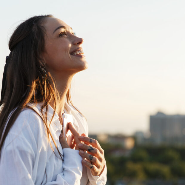 beautiful young woman smiles tender standing on the rooftop in t
