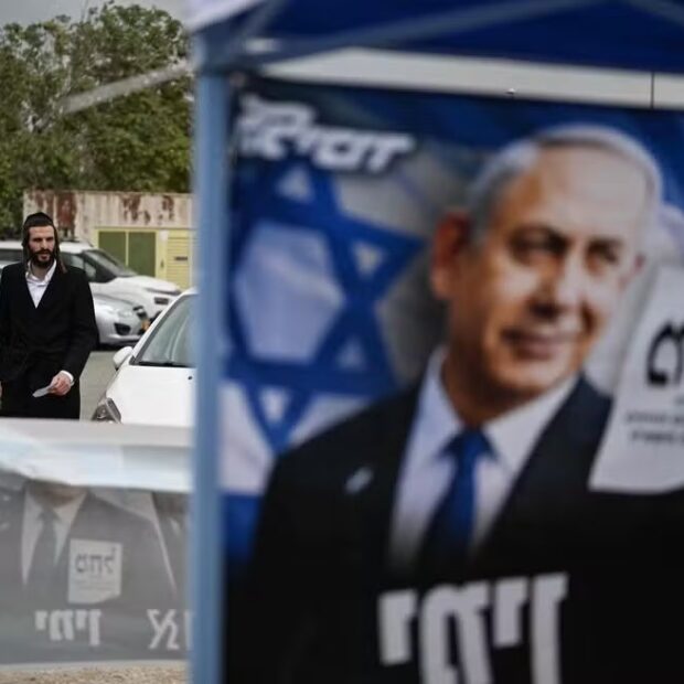 116732224 a voter walks past campaign posters of prime minister benjamin netanyahu as he arrives at